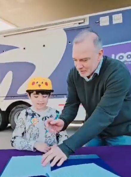 Enrique Cintolesi con un niño mostrándole su tecnología